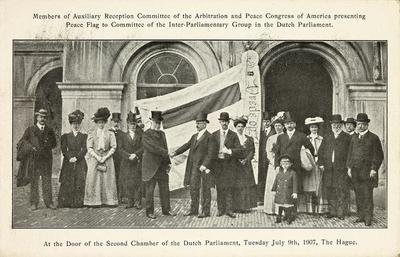 Members of Auxiliary Reception Committee of the Arbitration and Peace Congress of America presenting Peace Flag to Committee of the Interparliamentary Group in the Dutch Parliament. At the Door of the Second Chamber of the Dutch Parliament, Tuesday July 9yh, 1907, The Hague